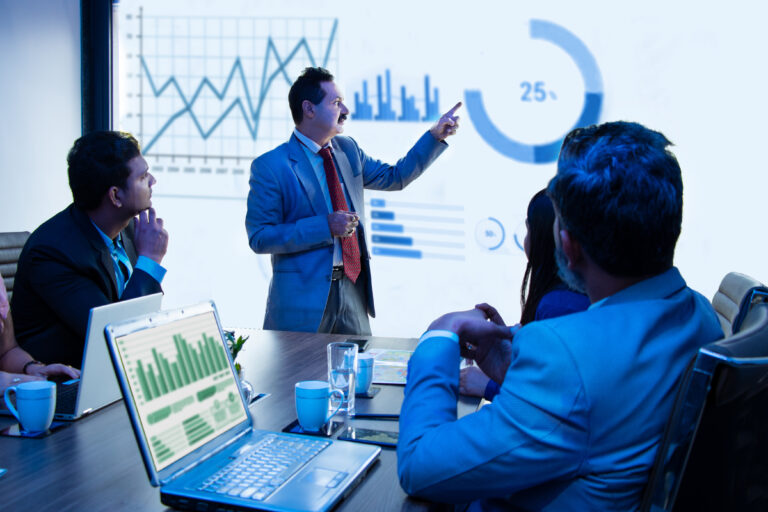 Indian business people meeting presentation in office conference room showing Infographics graphs on projector screen, Revenue growth strategy and analysis.Product sales